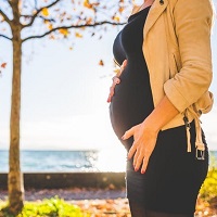 Profile of a pregnant lady with hands on her bump