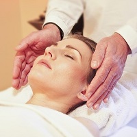 Reiki treatment with hands at the temples