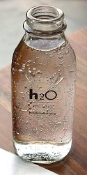 Bottle of water with condensation and h2o written on the label