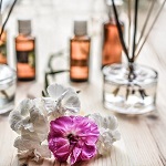 White and purple flowers with aromatherapy diffuser and oils in the background