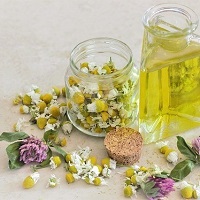 Bottle of oil and a jar with pink, yellow and white flowers