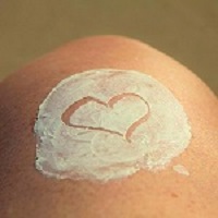 Circle of lotion on skin with heart shape 