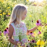 Young girl in a field surrounded by flowers