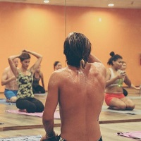 Back view of teacher at the front of the class in a Hot Yoga studio