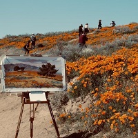 Artist's easel and painting of landscape with people and orange flowers