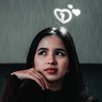 Girl in contemplation with love hearts and question marks above her head