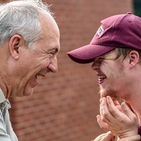 Profiles of father and son smiling heartily at each other