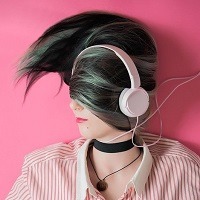 Head and shoulder shot of a girl wearing pink headphones